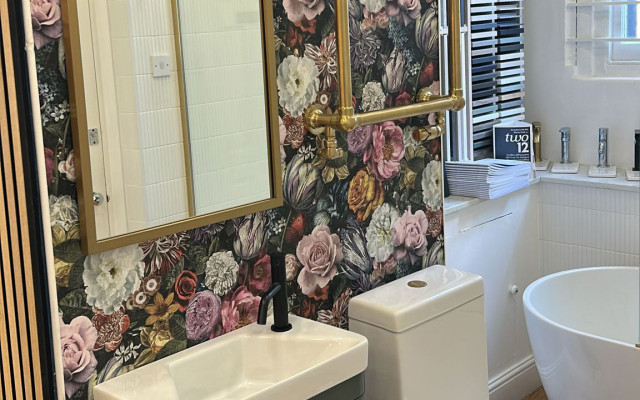 Elegant bathroom with floral wallpaper and gold accents